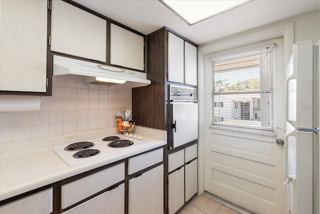 100 Glennes Ln Unit 207, Dunedin, FL 34698 - kitchen featuring under cabinet range hood, white appliances, light countertops, backsplash, and light tile patterned floors