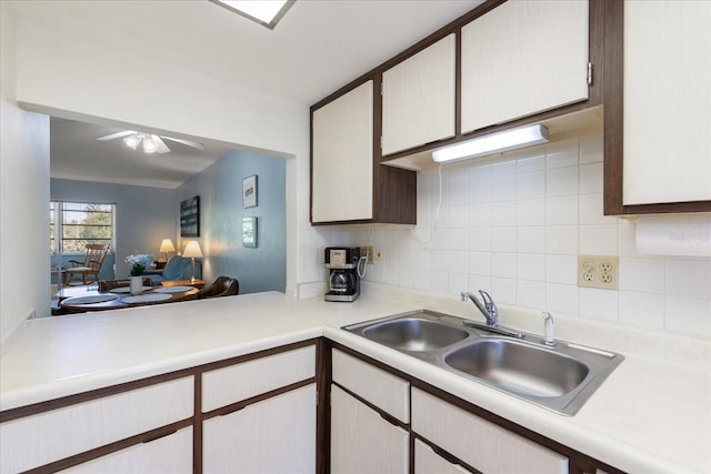 100 Glennes Ln Unit 207, Dunedin, FL 34698 - kitchen with light countertops, tasteful backsplash, a sink, and a ceiling fan