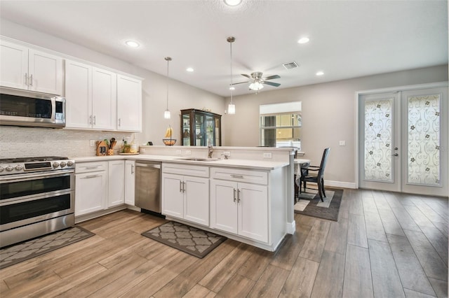4007 W Gray St, Tampa, FL 33609 - kitchen featuring stainless steel appliances, a peninsula, a sink, visible vents, and light countertops