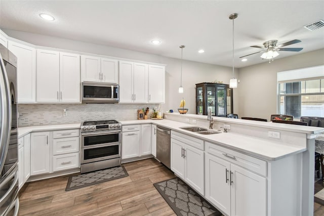 4007 W Gray St, Tampa, FL 33609 - kitchen with white cabinets, visible vents, a sink, a peninsula, and appliances with stainless steel finishes
