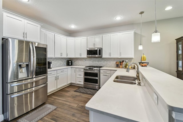 4007 W Gray St, Tampa, FL 33609 - kitchen featuring dark wood-style floors, light countertops, a sink, a peninsula, and appliances with stainless steel finishes