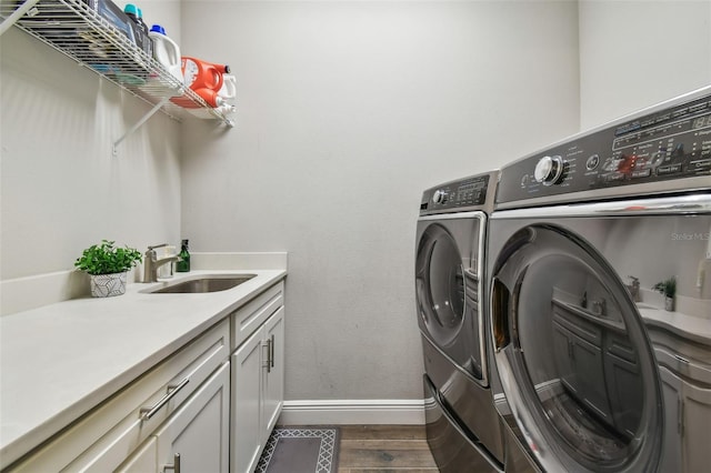 4007 W Gray St, Tampa, FL 33609 - laundry area with a sink, dark wood-style flooring, washing machine and dryer, baseboards, and cabinet space