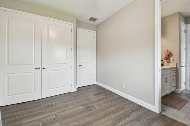 4007 W Gray St, Tampa, FL 33609 - unfurnished bedroom with baseboards, wood finished floors, visible vents, and a closet