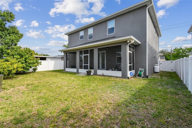 4007 W Gray St, Tampa, FL 33609 - back of house with stucco siding, a sunroom, a fenced backyard, and a lawn