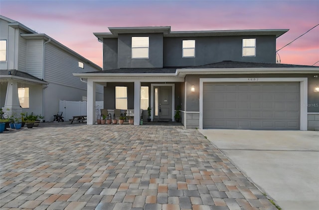 4007 W Gray St, Tampa, FL 33609 - traditional home with stucco siding, a garage, concrete driveway, and covered porch