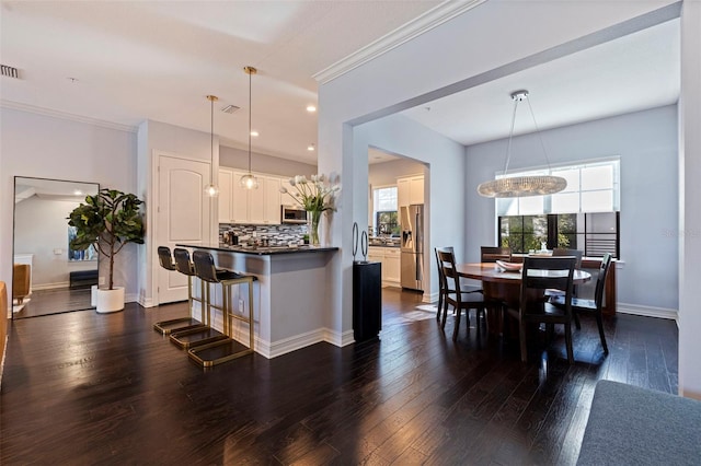 kitchen with backsplash, dark countertops, dark wood-style floors, white cabinets, and appliances with stainless steel finishes