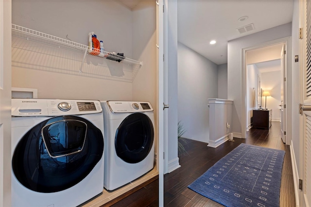 washroom with washing machine and clothes dryer, wood finished floors, laundry area, baseboards, and visible vents