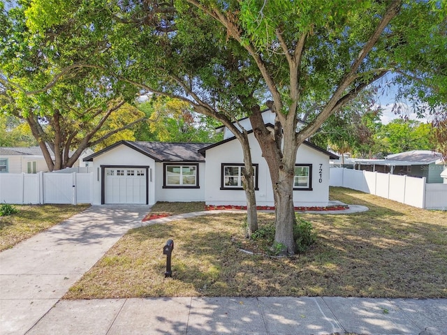 7210 8th Ave N, Saint Petersburg, FL 33710 - view of front of house with an attached garage, concrete driveway, a gate, and stucco siding
