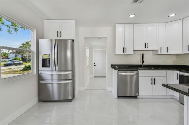 7210 8th Ave N, Saint Petersburg, FL 33710 - kitchen featuring appliances with stainless steel finishes, dark stone counters, white cabinetry, recessed lighting, and light tile patterned flooring