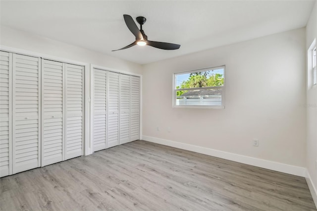 7210 8th Ave N, Saint Petersburg, FL 33710 - unfurnished bedroom with wood finished floors, two closets, and a ceiling fan
