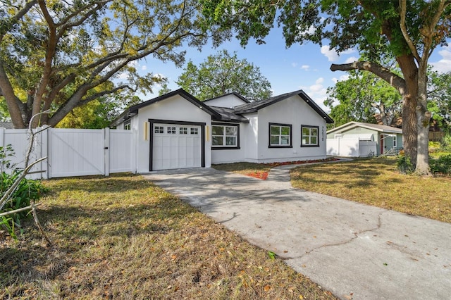 7210 8th Ave N, Saint Petersburg, FL 33710 - ranch-style house featuring a gate, a garage, driveway, and stucco siding