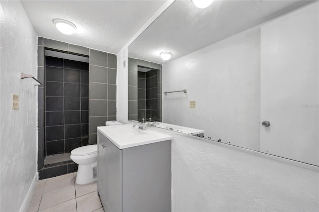 bathroom featuring a textured ceiling, toilet, vanity, and tile patterned floors