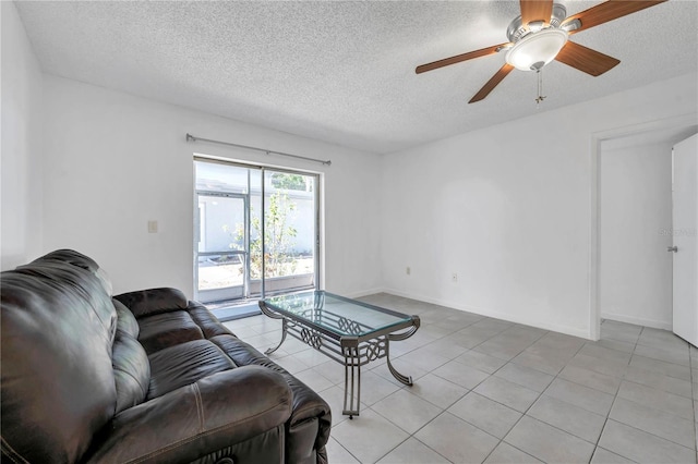 living area with a textured ceiling, a ceiling fan, baseboards, and light tile patterned floors