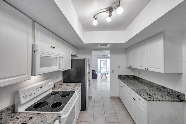 kitchen featuring white cabinets, white appliances, a raised ceiling, and light tile patterned floors