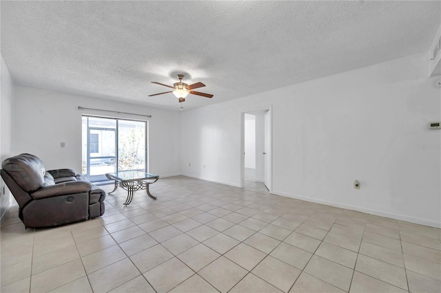 unfurnished living room featuring a textured ceiling, baseboards, ceiling fan, and light tile patterned floors