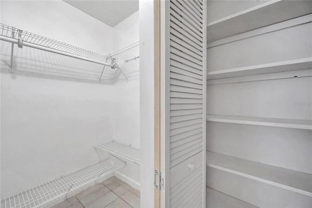 spacious closet featuring tile patterned flooring