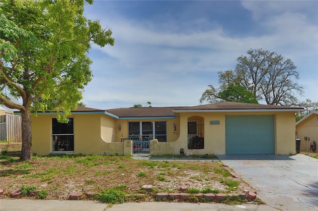 single story home with stucco siding, a garage, and concrete driveway