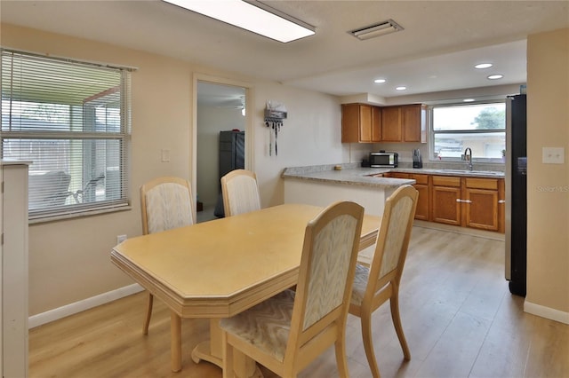 dining space with light wood finished floors, baseboards, and recessed lighting