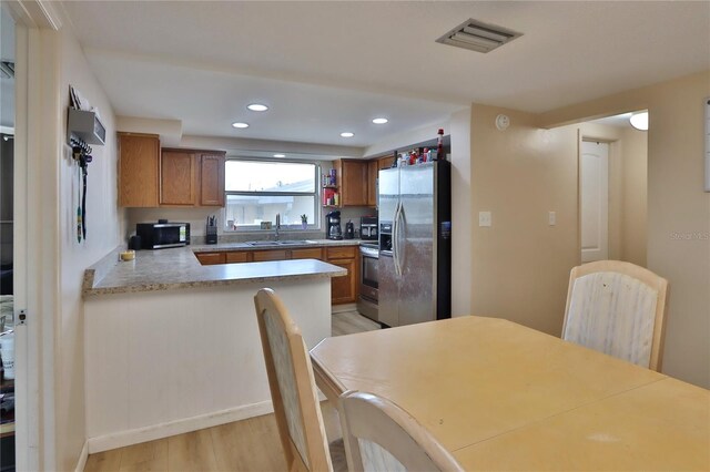 kitchen with recessed lighting, a sink, visible vents, appliances with stainless steel finishes, and brown cabinets
