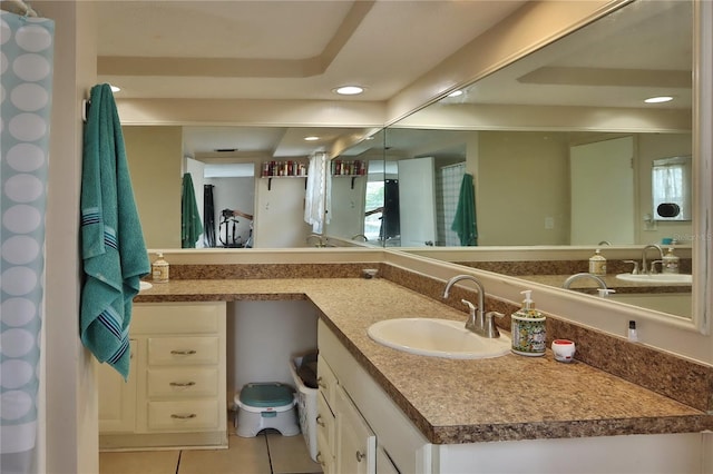 full bath with a tray ceiling, recessed lighting, tile patterned flooring, and vanity