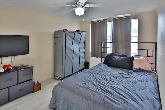 bedroom with a ceiling fan and light wood-style flooring