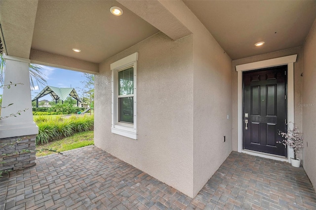 doorway to property featuring stucco siding