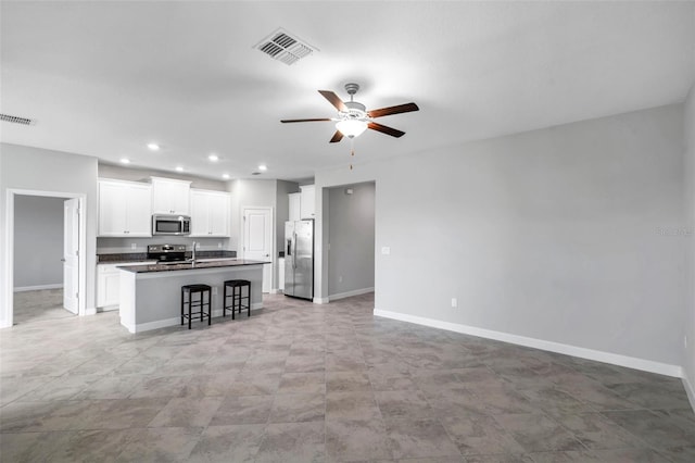 kitchen with stainless steel appliances, visible vents, a ceiling fan, and dark countertops