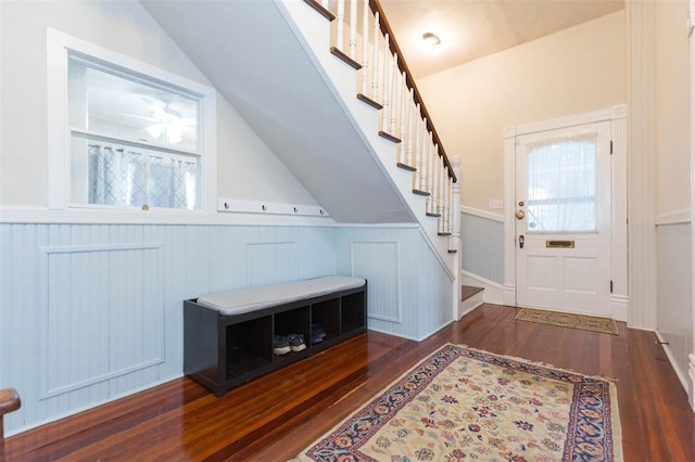 interior space with vaulted ceiling, stairway, wainscoting, and hardwood / wood-style flooring