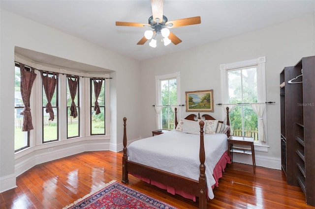 bedroom with baseboards, a ceiling fan, and hardwood / wood-style flooring