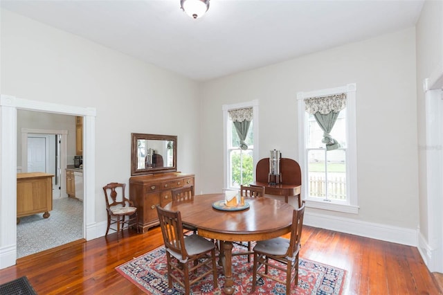 dining space with baseboards and light wood-type flooring