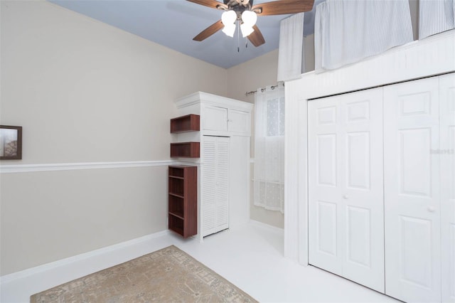 interior space featuring a ceiling fan and a closet
