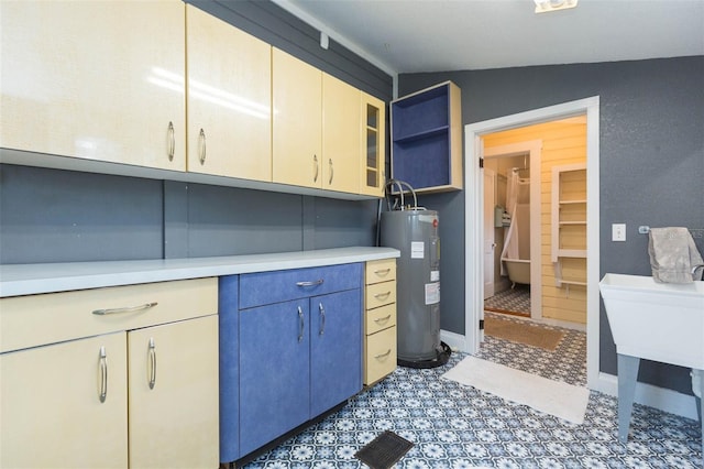 kitchen featuring electric water heater, light countertops, lofted ceiling, and open shelves