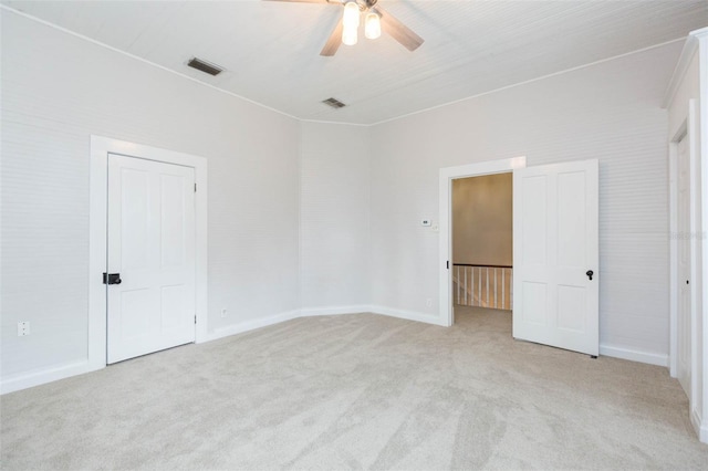 unfurnished bedroom featuring ceiling fan, visible vents, and light colored carpet