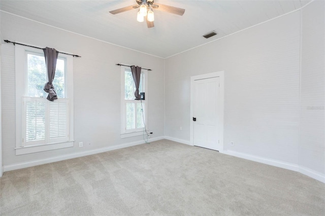 unfurnished room with baseboards, a ceiling fan, visible vents, and carpet