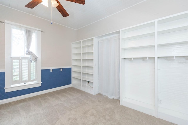carpeted empty room featuring vaulted ceiling and a ceiling fan