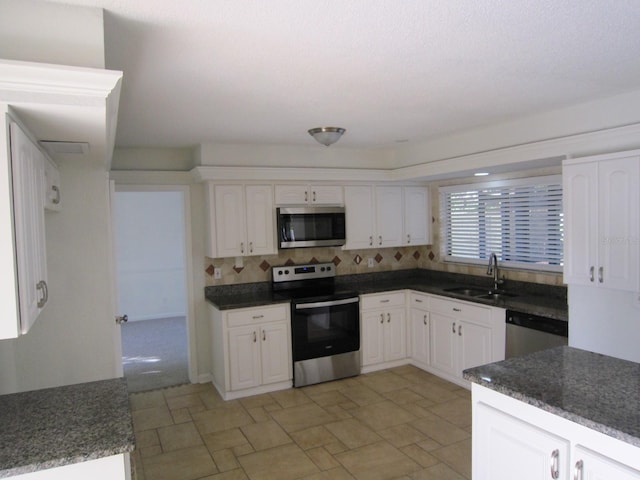 4118 Dellbrook Dr, Tampa, FL 33624 - kitchen with white cabinetry, stone finish flooring, a sink, and stainless steel appliances