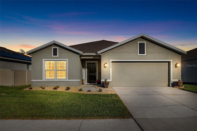 ranch-style home featuring stucco siding, a garage, driveway, and a front lawn