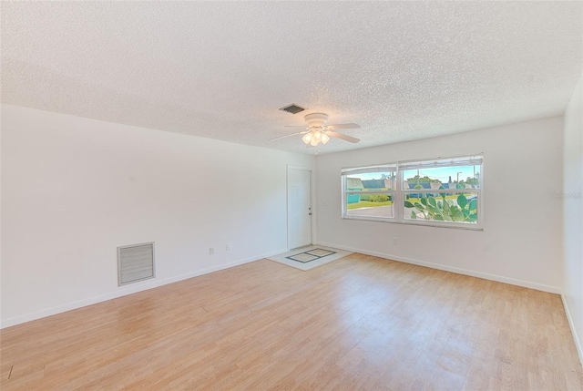 unfurnished room with visible vents, light wood-type flooring, and a ceiling fan
