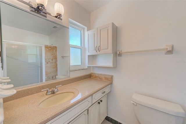 full bathroom featuring visible vents, a tile shower, toilet, and vanity