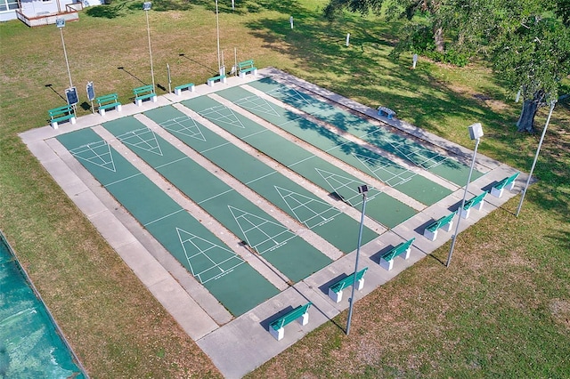 view of home's community with shuffleboard and a yard