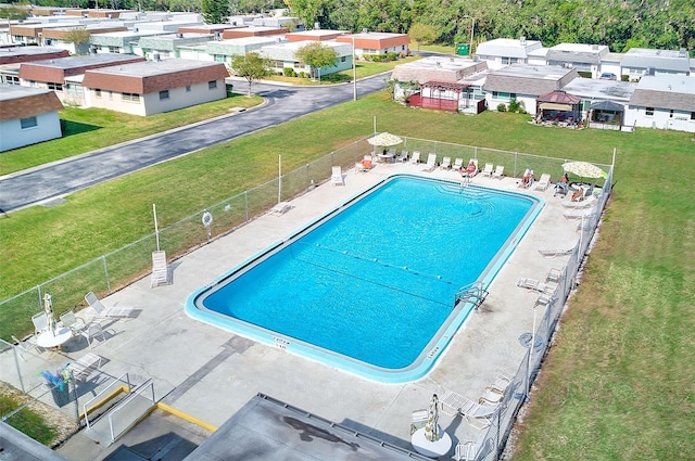 pool featuring fence, a patio area, and a residential view