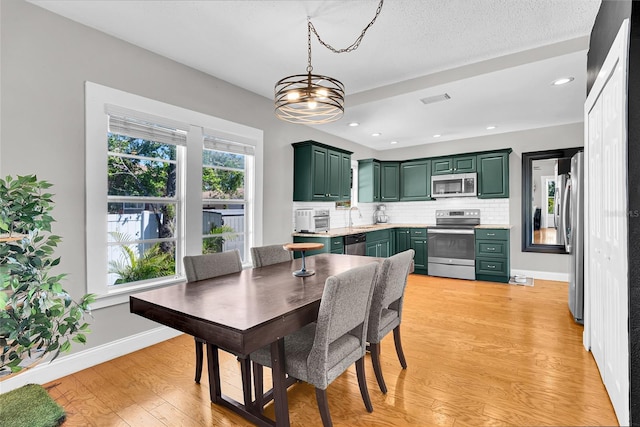 705 28th St N, Saint Petersburg, FL 33713 - dining room featuring a chandelier, baseboards, visible vents, light wood-style floors, and recessed lighting