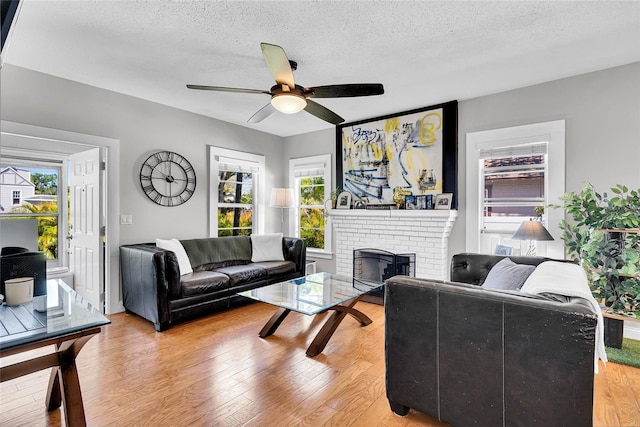 705 28th St N, Saint Petersburg, FL 33713 - living area with plenty of natural light, a fireplace, light wood-style floors, and a ceiling fan
