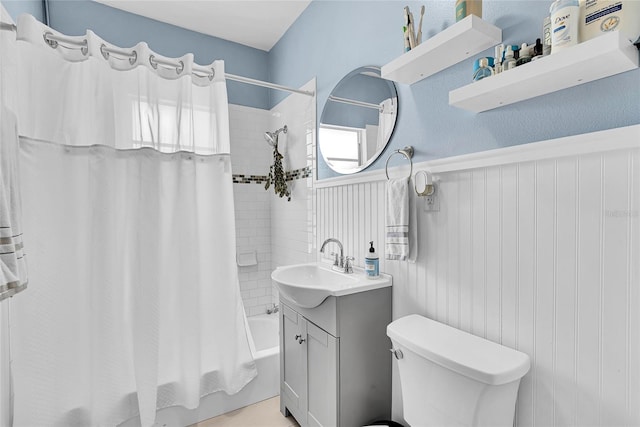 705 28th St N, Saint Petersburg, FL 33713 - bathroom with vanity, shower / bathtub combination with curtain, toilet, and wainscoting