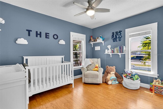 705 28th St N, Saint Petersburg, FL 33713 - bedroom featuring wood finished floors, multiple windows, and a nursery area
