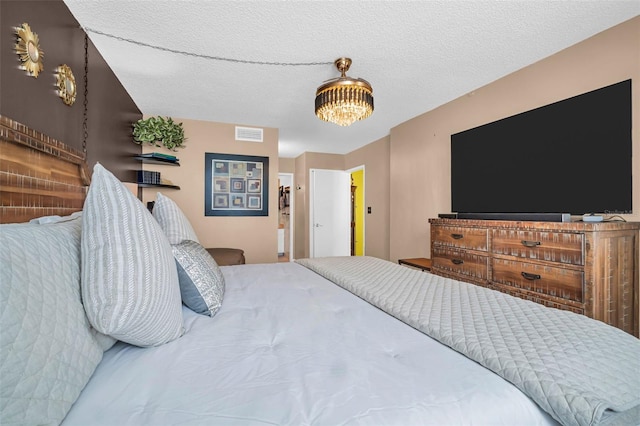 bedroom featuring a textured ceiling and visible vents