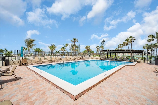 pool with a patio and fence