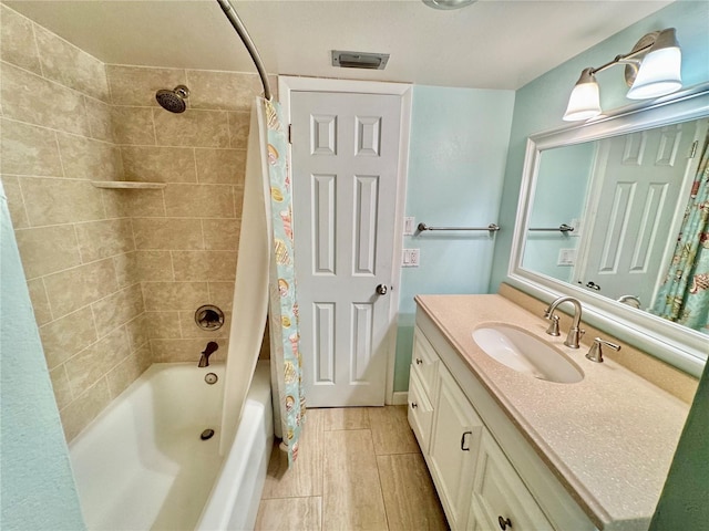 full bath with visible vents, shower / bathtub combination with curtain, wood finished floors, and vanity
