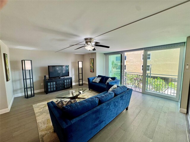 1390 Gulf Blvd Unit 104, Clearwater, FL 33767 - living area featuring wood finished floors, a ceiling fan, and a wall of windows