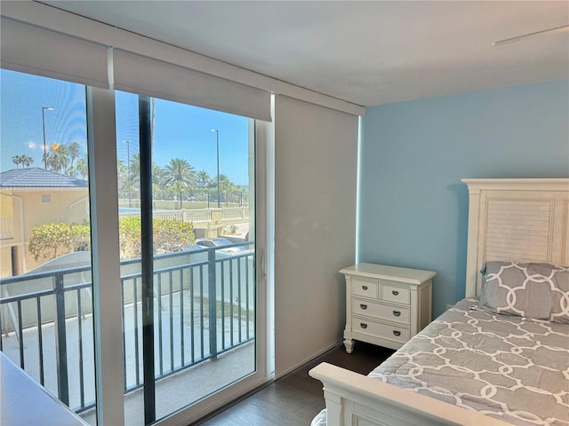 1390 Gulf Blvd Unit 104, Clearwater, FL 33767 - bedroom with access to exterior and dark wood-style flooring